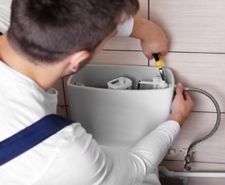 Plumber fixing toilet cistern water closet