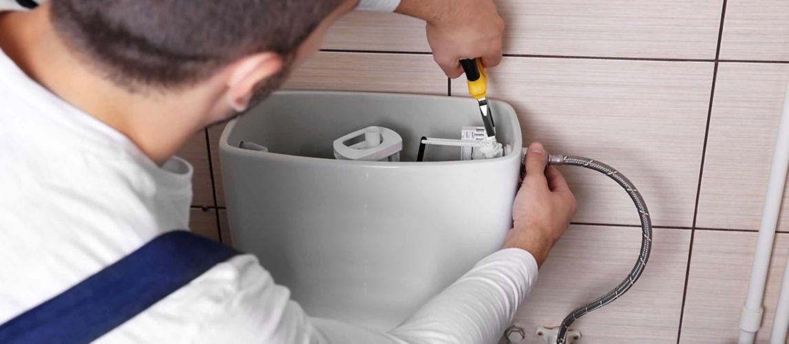 Plumber fixing toilet cistern water closet