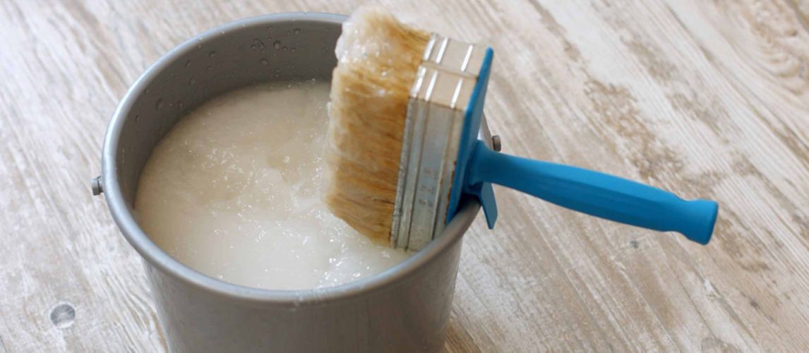 Bucket of wallpaper paste with a brush