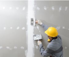 Worker applying plaster to a drywall joint.